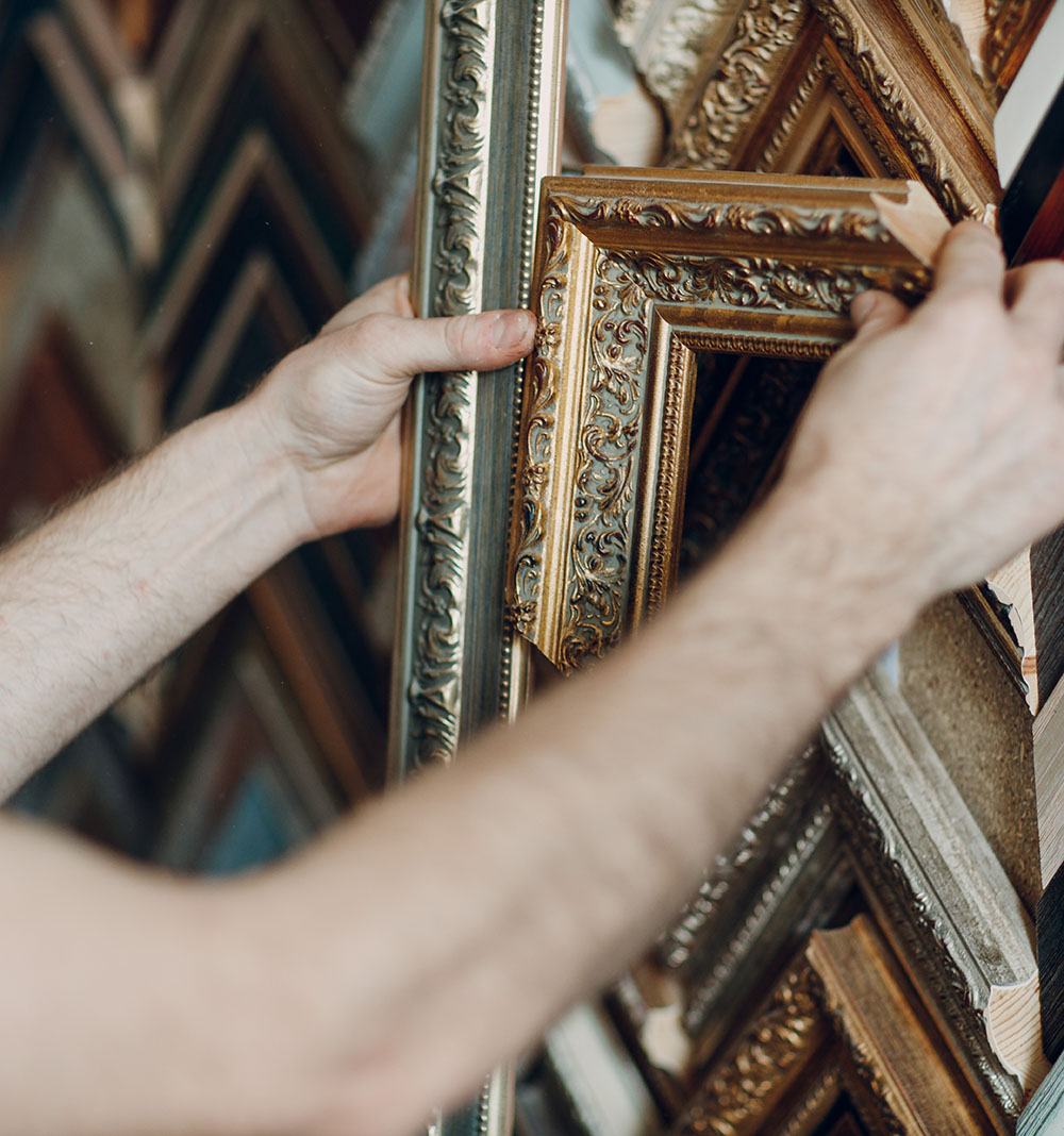 Hands holding frame moulding.